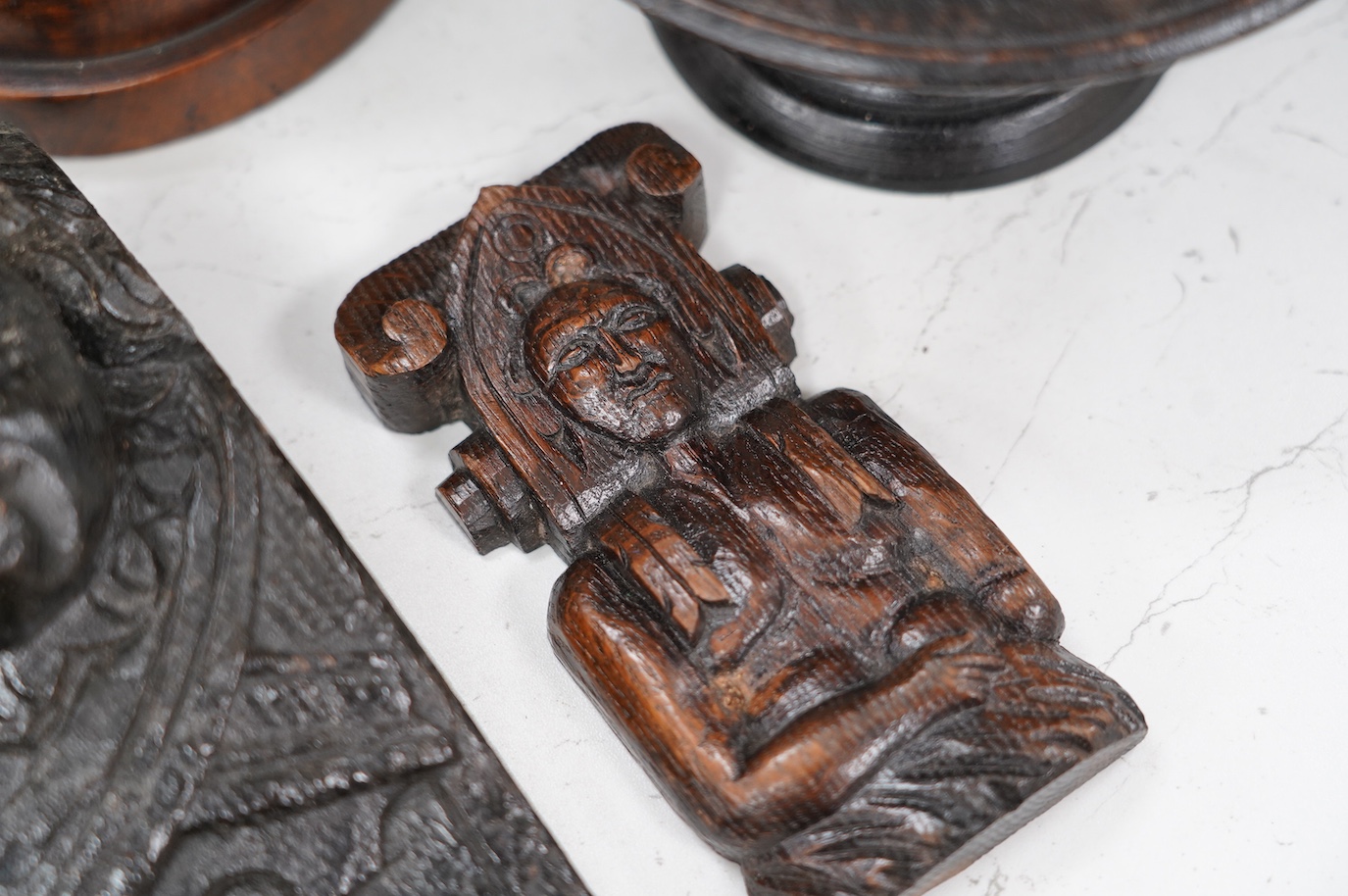 A 17th century carved oak mask corbel, another smaller, a small tazza and a carved wood pot and cover, tallest 19.5cm. Condition - fair to good